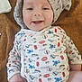 baby, smiling, onesie, knitted_cap, blanket, happy, infant, cute, child, face, clothing, patterned, indoor, soft_texture, skin, laying_down, joy, expression, young_child, comfort