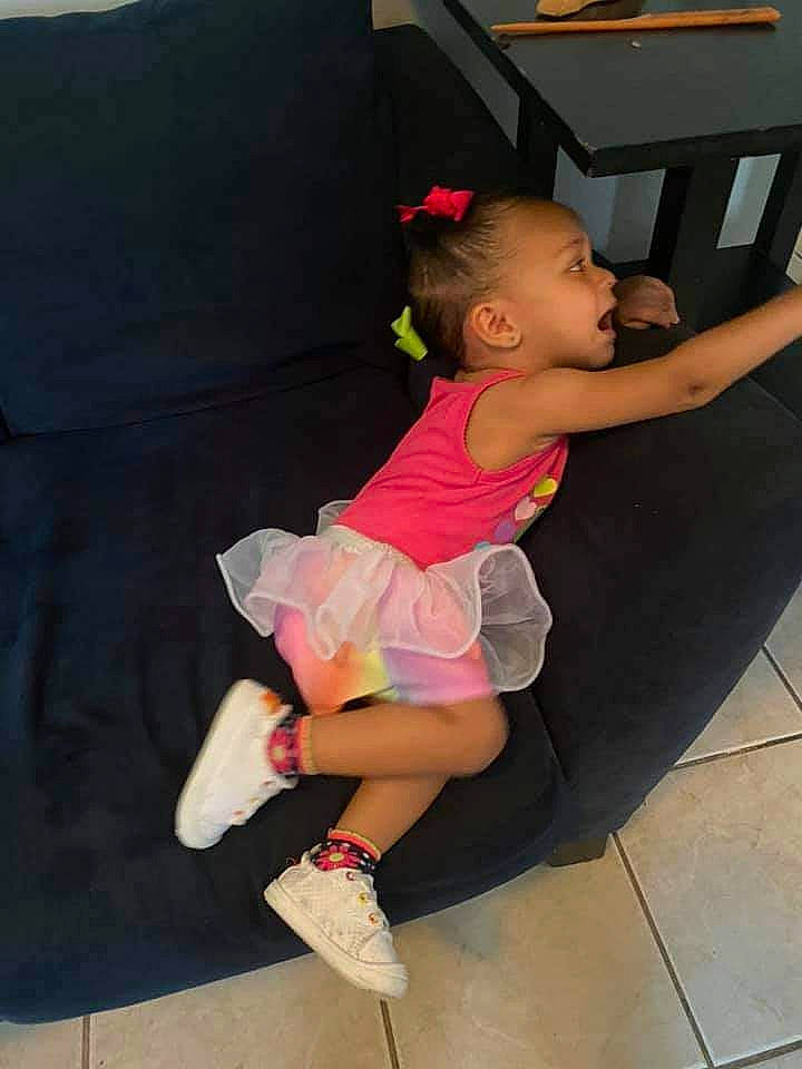 Jaida joined the competition — help win amazing prizes! baby_toddler_clothing, child, couch, flooring, foot, human_body, human_leg, knee, leg, leisure, magenta, person, recreation, sandal, shoe, shoulder, sitting, sock, t_shirt, thigh
