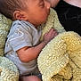 baby, newborn, sleeping, blanket, soft_texture, infant, peaceful, cozy, closeup, person, skin, clothing, arm, hand, head, face, resting, black_top, indoor, warm
