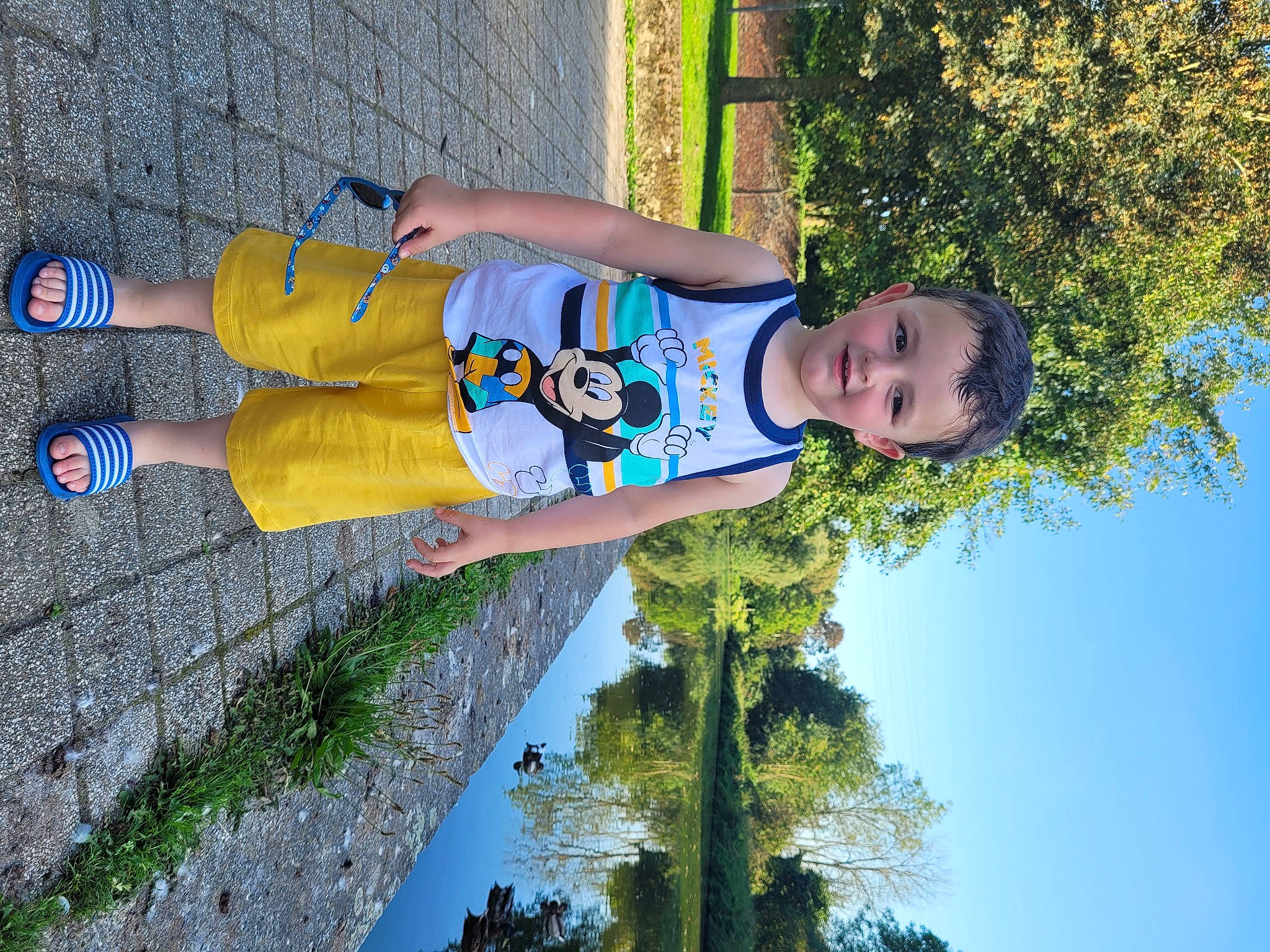 Robin participe au concours pour gagner de l'argent avec cette photo : baby_toddler_clothing, blue, child, electric_blue, fun, grass, happy, human_leg, joy, leisure, people_in_nature, person, plant, recreation, shadow, sky, t_shirt, toddler, tree, vacation