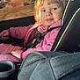 toddler, child, car_seat, pink_clothing, seatbelt, window, excavator, construction, sunlight, blonde_hair, curious, car_interior, seatbelt_strap, casual, daytime, portrait, vehicle, safety, young_child, looking