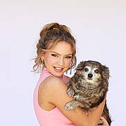 Lucy joined the competition — help win amazing prizes! woman, dog, smiling, pet, portrait, casual_clothing, pink_top, jeans, holding, fluffy_dog, indoor, light_background, happy, friendly, hair_up, earrings, young_adult, cute_pet, affection, posing