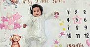 Aaira joined the competition — help win amazing prizes! baby, infant, child, blanket, milestone, months, pink, stars, teddy_bear, clouds, onesie, curly_hair, bow, cute, laying_down, age_marker, numbers, reaching, portrait, indoor