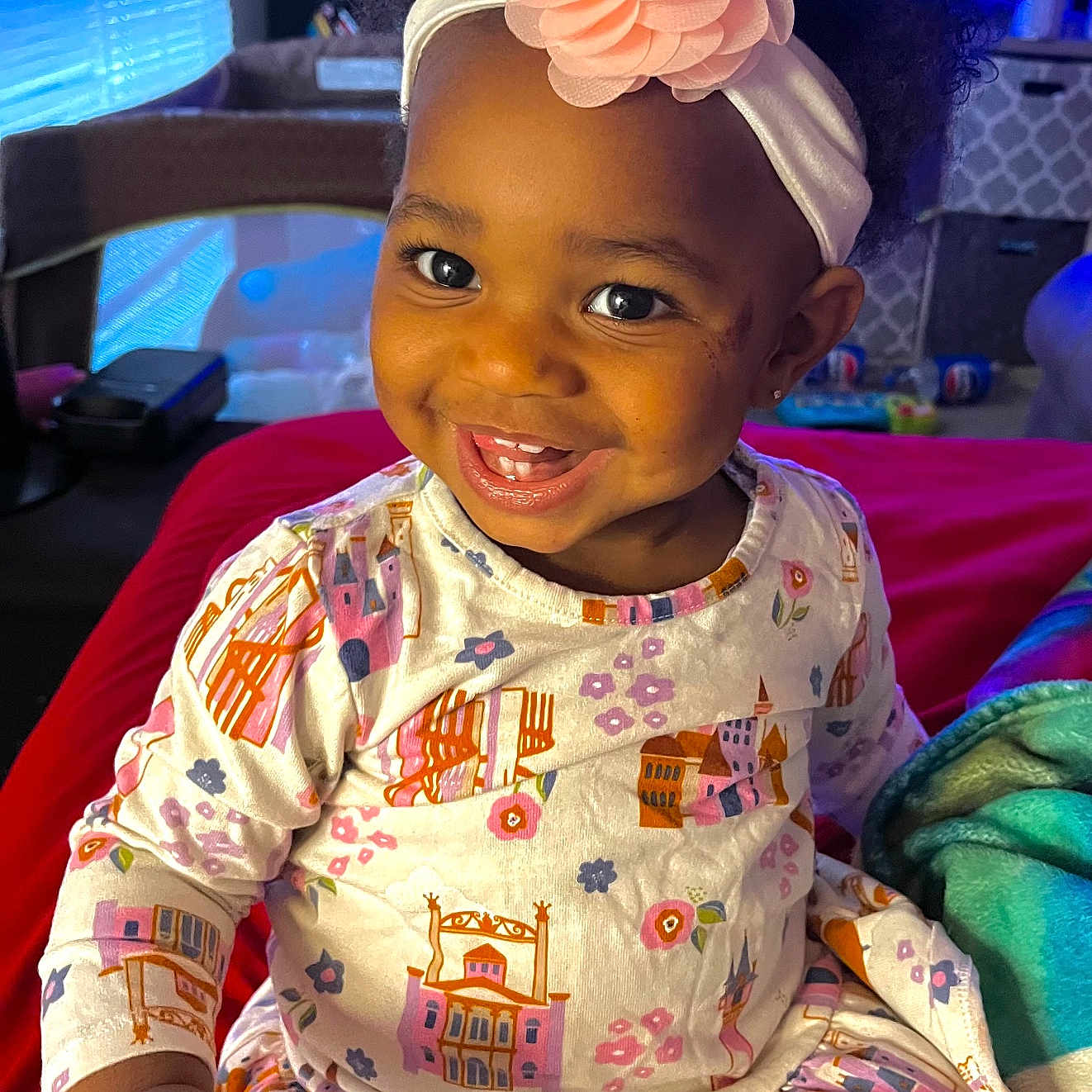 Kehlani is registered to the contest to win money with this photo: bed, blanket, child, cozy, curly_hair, cute, face, flower, furniture, hand, happy, headband, home, indoor, pajamas, person, portrait, sitting, smiling, toddler