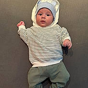 Thomas a rejoint le concours — aidez-le/la à gagner de superbes lots ! baby, infant, hoodie, striped_sweater, blue_hat, socks, car_pattern, lying_down, grey_background, cute, child, portrait, clothing, casual, indoor, small_hands, face, headwear, comfort, soft_surface