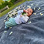 baby, infant, flower, blanket, outdoor, grass, nature, cute, portrait, child, young, soft, clothing, white, green, relaxing, lying_down, small, peaceful, daylight