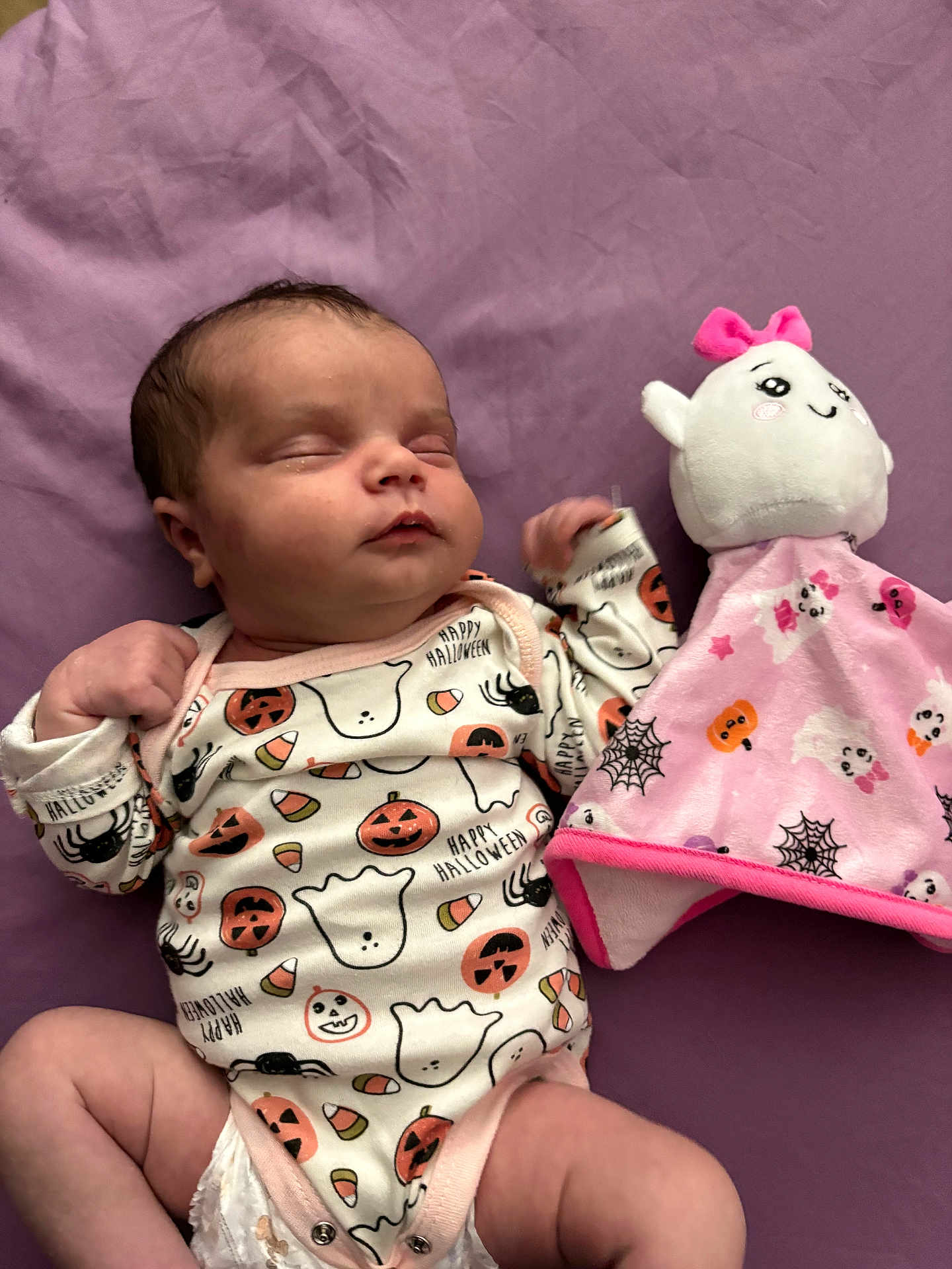 Ivey is registered to the contest to win money with this photo: baby, sleeping, onesie, halloween, pumpkin, ghost, spider, plush_toy, pink, purple, blanket, infant, cute, soft, toy, child, sleep, peaceful, clothing, indoor