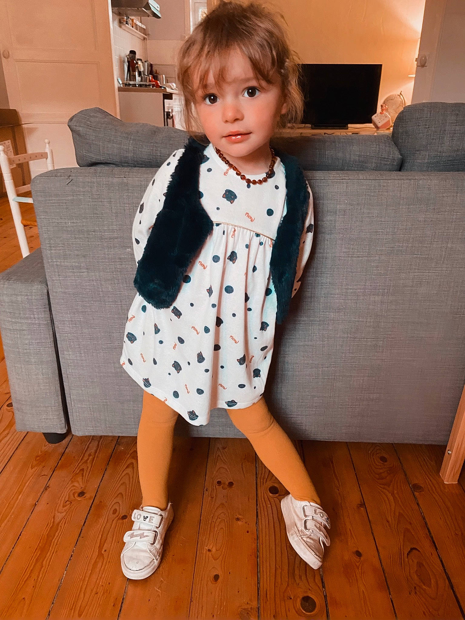 Lydia participe au concours pour gagner de l'argent avec cette photo : baby_toddler_clothing, blazer, collar, couch, dress, face, flooring, formal_wear, joint, knee, lamp, neck, pattern, person, picture_frame, sleeve, standing, street_fashion, toddler, white
