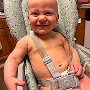 Christopher is registered to the contest to win money with this photo: baby, high_chair, smiling, diaper, harness, indoor, kitchen, child, cute, happy, seat, furniture, person, skin, face, hand, expression, food_stain, colorful, domestic