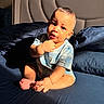 baby, child, infant, bed, bedding, pillow, blanket, blue, sunlight, shadow, skin, face, hand, foot, sitting, clothing, room, headboard, curious, indoors