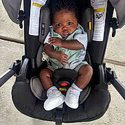 Kashmir joined the competition — help win amazing prizes! baby, infant, car_seat, child, white_sneakers, mint_green_outfit, curly_hair, sitting, strapped_in, outdoor, concrete, cute, secure, serious_expression, footwear, clothing, infant_baby, seat, young_child, portrait