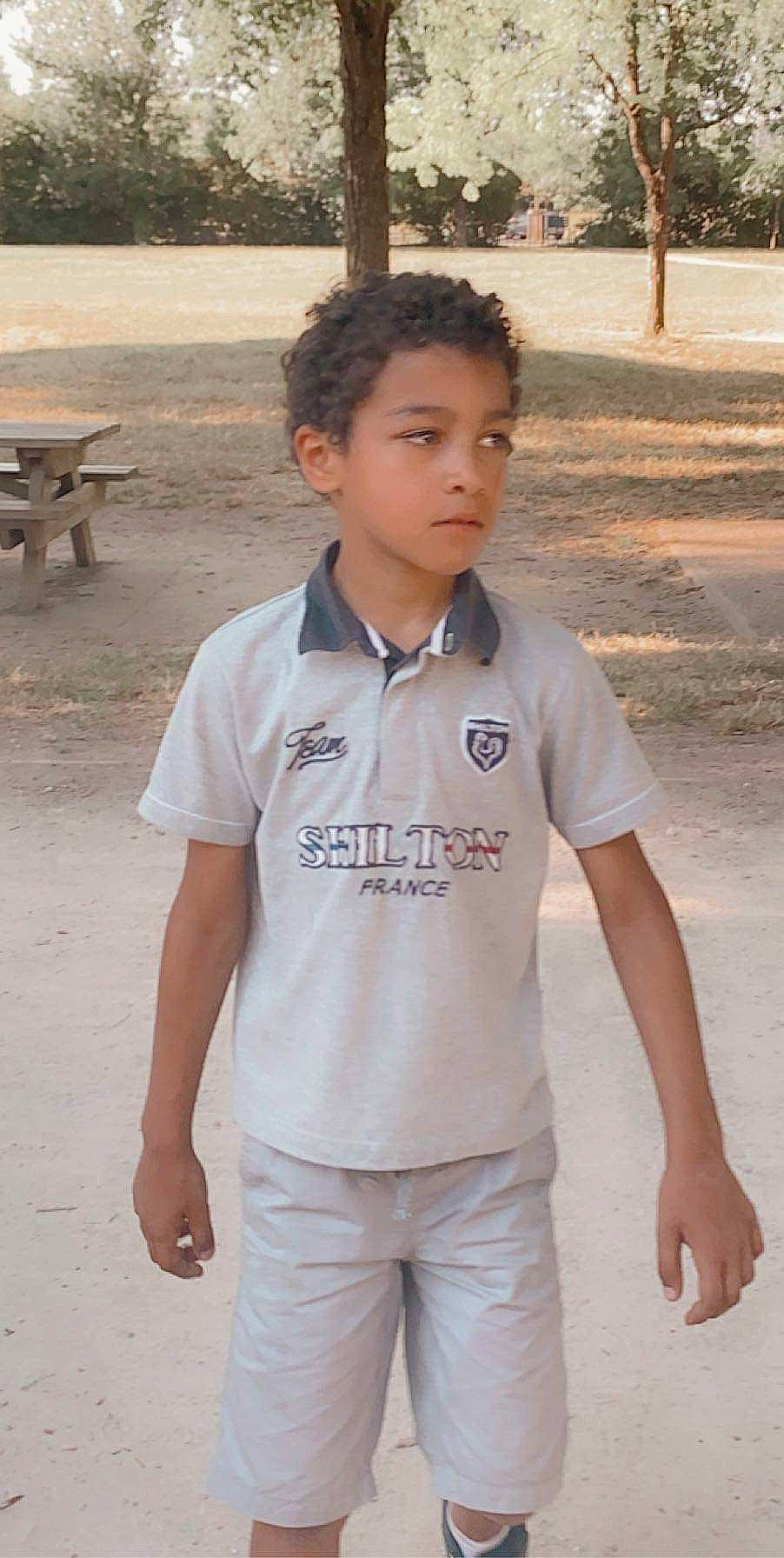 Elizio a rejoint le concours — aidez-le/la à gagner de superbes lots ! beige, child, clothing, neck, person, polo_shirt, shoulder, sleeve, smile, standing, t_shirt, top