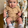 baby, child, high_chair, smiling, blue_eyes, sneakers, white_shoes, beige_outfit, shorts, shirt, indoor, happy, cute, person, footwear, sock, seat, furniture, infant, young_child