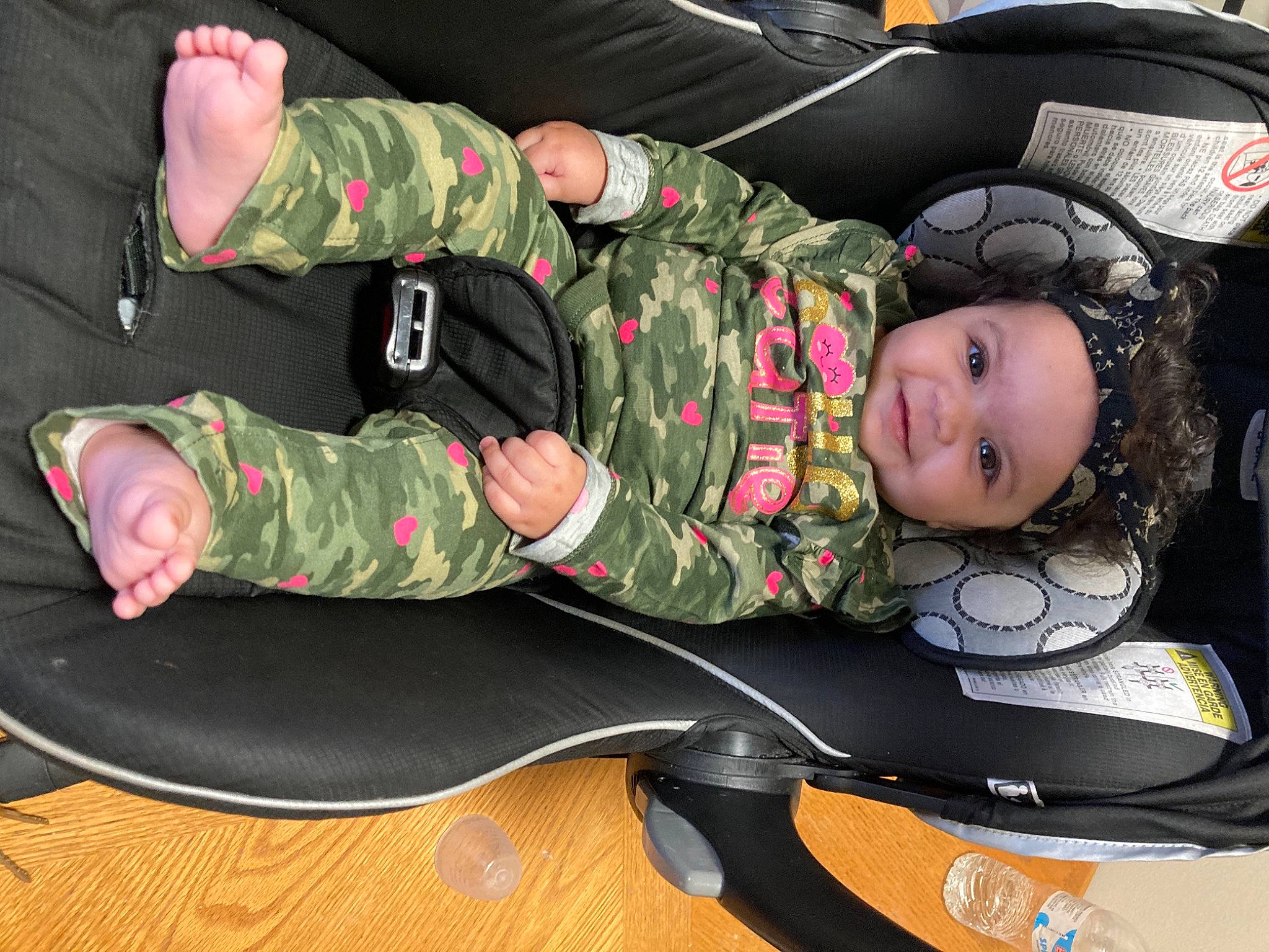 Arianna is registered to the contest to win money with this photo: baby_toddler_clothing, boot, camouflage, child, comfort, facial_expression, fun, headwear, human_body, joy, leg, marines, military_camouflage, military_person, military_uniform, non_commissioned_officer, pattern, person, shoe, smile