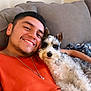 Rocket San Miguel joined the competition — help win amazing prizes! man, dog, smiling, couch, orange_shirt, pet, curly_fur, indoor, happy, relaxed, home, canine, companion, portrait, casual, friendship, cozy, furniture, resting, cute