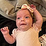 Athena joined the competition — help win amazing prizes! baby, infant, child, pink_clothing, headband, bow, blanket, lying_down, cute, playful, skin, person, face, hand, newborn, soft_texture, expression, indoors, smile, toddler