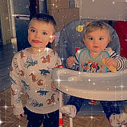 Bryan participe au concours pour gagner de l'argent avec cette photo : child, baby, high_chair, pajamas, snack, floor, socks, indoor, home, person, furniture, toy, smiling, happy, cute, sparkles, face, clothing, young_child, family