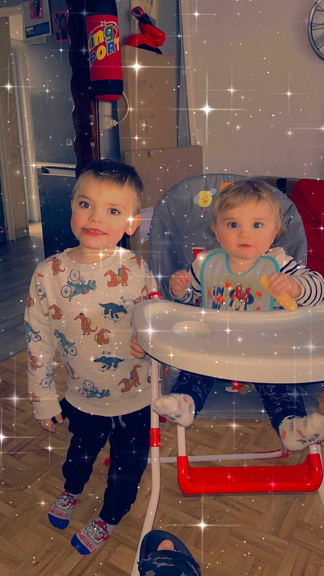 Bryan participe au concours pour gagner de l'argent avec cette photo : child, baby, high_chair, pajamas, snack, floor, socks, indoor, home, person, furniture, toy, smiling, happy, cute, sparkles, face, clothing, young_child, family