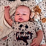 baby, infant, mickey_mouse, onesie, plush_toy, lion_toy, blanket, stars_pattern, child, cute, relaxed, lying_down, soft, cozy, indoor, portrait, smiling, hand, face, clothing