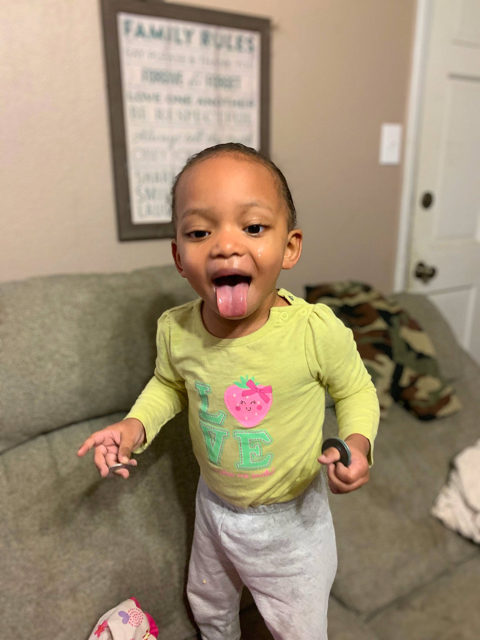 Malikiah is registered to the contest to win money with this photo: baby, baby_toddler_clothing, cheek, child, comfort, door, floor, flooring, gesture, happy, nose, person, room, skin, sleeve, smile, standing, t_shirt, thumb, toddler