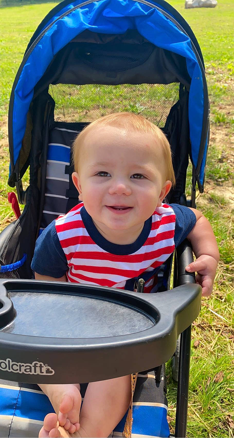 Eastyn is registered to the contest to win money with this photo: baby_carriage, blue, chair, child, eye, facial_expression, fun, grass, green, happy, human_body, joy, leisure, person, photograph, plant, product, public_space, skin, smile