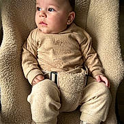 Léandro a rejoint le concours — aidez-le/la à gagner de superbes lots ! baby, child, infant, seat, cushion, clothing, socks, face, person, indoor, soft_texture, beige, warm_clothes, cute, portrait, looking_away, baby_seat, comfort, hands, expression