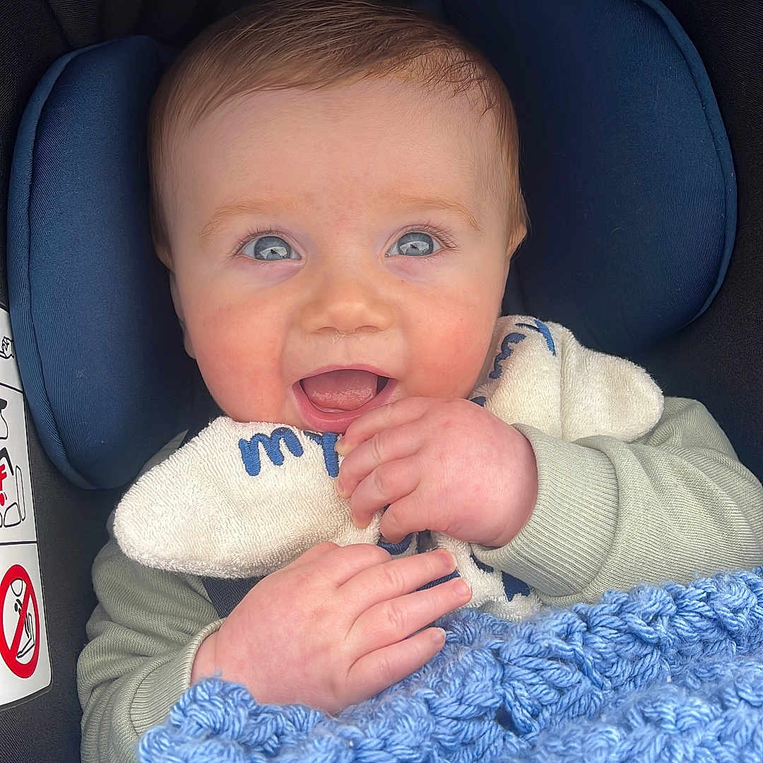 Teddy-George is registered to the contest to win money with this photo: baby, blanket, bodypart, clothing, couch, cushion, face, finger, furniture, hand, happy, head, homedecor, laughing, newborn, pants, person, photography, portrait, smile