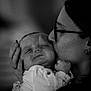 Elyo a rejoint le concours — aidez-le/la à gagner de superbes lots ! baby, infant, adult, kissing, affection, close_up, portrait, glasses, earring, hand, ring, sleeping, black_and_white, grainy, indoor, cozy, clothing, face, holding, emotional