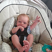 Casey is registered to the contest to win money with this photo: baby, baby_seat, child, closeup, clothing, comfort, cushion, cute, foot, hand, indoor, infant, newborn, pacifier, person, reaching_hand, relaxing, sitting, soft_lighting, straps