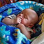 Casey is registered to the contest to win money with this photo: baby, blanket, blue, cartoon_character, cushion, cute, face, hand, indoors, infant, light, pattern, peaceful, person, portrait, resting, seat, sleeping, soft, thumb_sucking