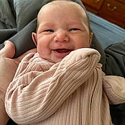 Charlotte joined the competition — help win amazing prizes! baby, smiling, infant, pink_clothing, ribbed_fabric, blanket, hand, indoor, portrait, happy, cute, face, newborn, cozy, furniture, dresser, bedroom, soft_light, skin, person