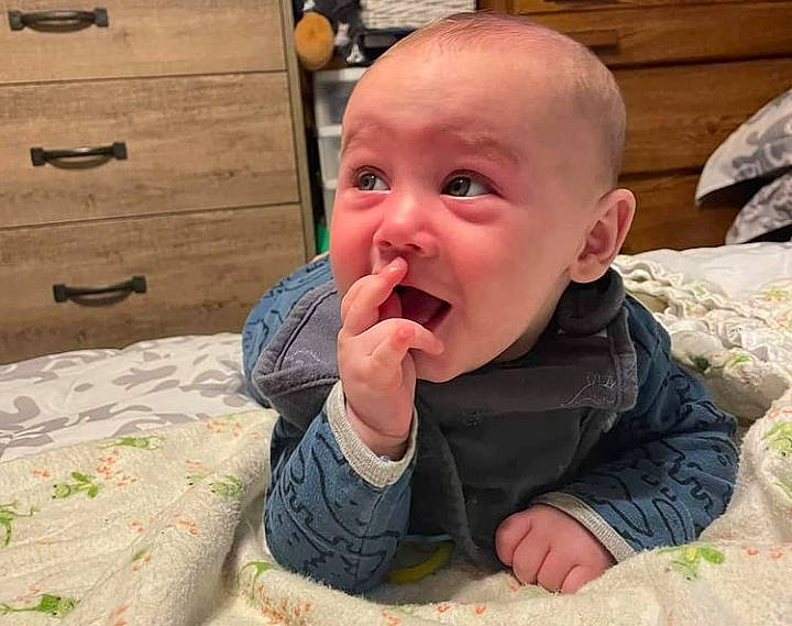 Cyrus is registered to the contest to win money with this photo: baby, baby_toddler_clothing, chair, cheek, child, comfort, drawer, flooring, fun, linens, nail, nose, person, room, sitting, skin, surprise, thumb, toddler, vacation