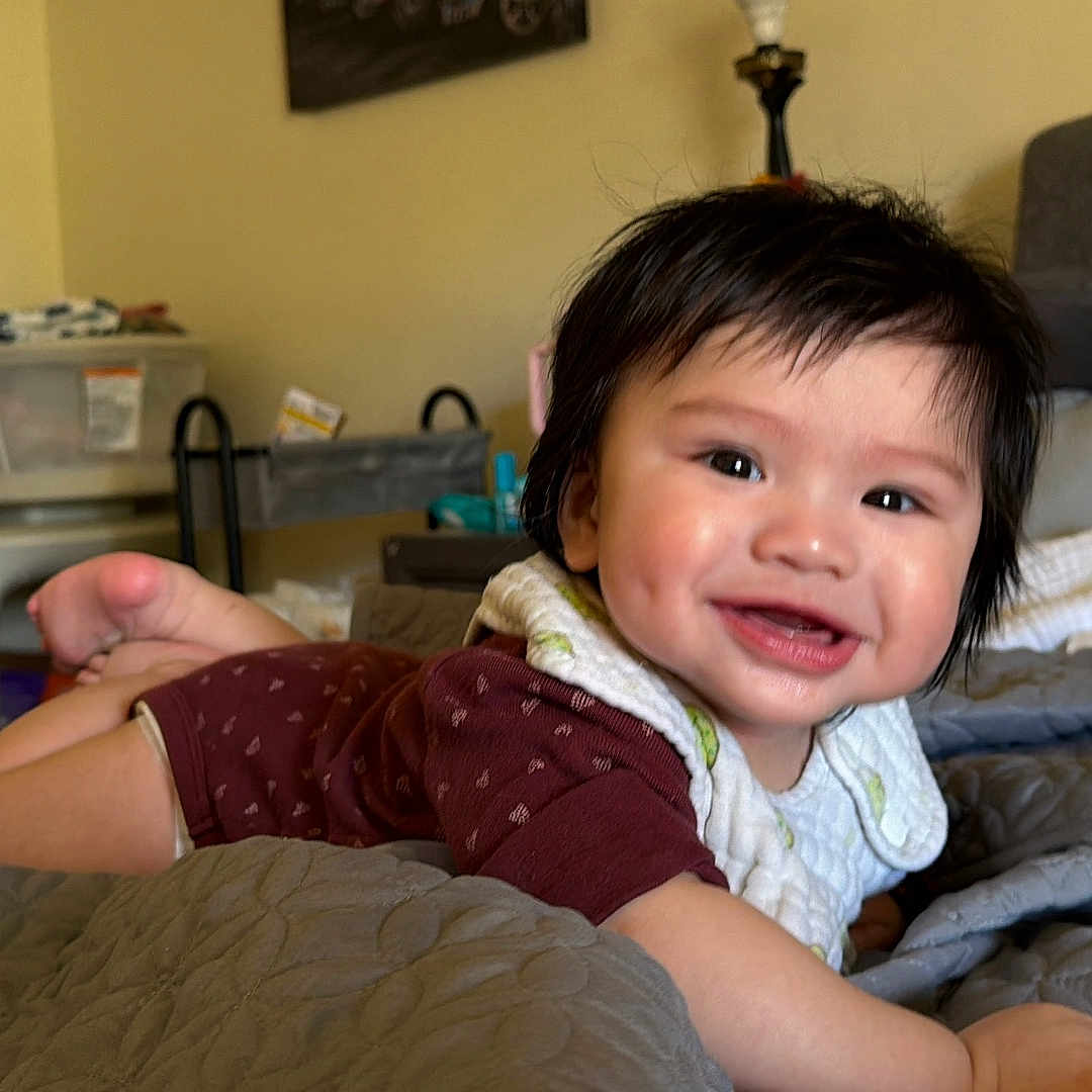 Xzavien Jheorge is registered to the contest to win money with this photo: baby, bed, bib, blanket, child, cute, diaper, dimple, face, furniture, hair, indoor, infant, lamp, nightstand, pillow, plush, quilt, smile, toy