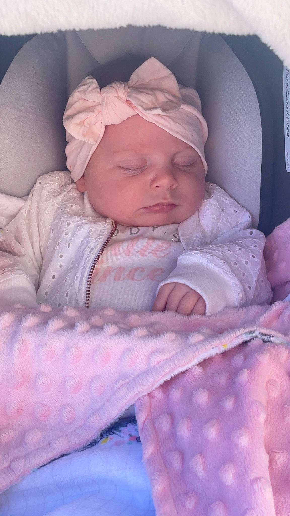 Remi is registered to the contest to win money with this photo: baby, baby_products, baby_safety, baby_sleeping, baby_toddler_clothing, cheek, child, comfort, head, headwear, linens, mouth, pattern, person, pink, room, sitting, skin, sleeve, textile