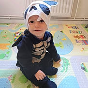 Aaron Kieffer participe au concours pour gagner de l'argent avec cette photo : baby, child, clothing, costume, cute, face, floor, hat, headwear, indoor, infant, play_mat, playtime, portrait, sitting, skeleton, smile, toddler, toy, young_child