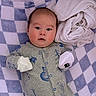 baby, infant, blanket, checkered, blue, white, mittens, clothing, face, person, sleepwear, cute, indoor, soft, newborn, expression, lying_down, cozy, fabric, portrait