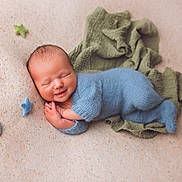 Emil joined the competition — help win amazing prizes! newborn, baby, smiling, knitted_outfit, blue_clothing, soft_blanket, felt_stars, green_cloth, sleeping, peaceful, infant, cute, portrait, cozy, hands_together, head, face, lying_down, warm_colors, indoor