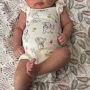 Angela is registered to the contest to win money with this photo: baby, infant, onesie, cartoon_print, blanket, leaf_pattern, cute, child, laying_down, skin, foot, hand, face, expression, indoors, sleepwear, soft_lighting, plush, young, resting