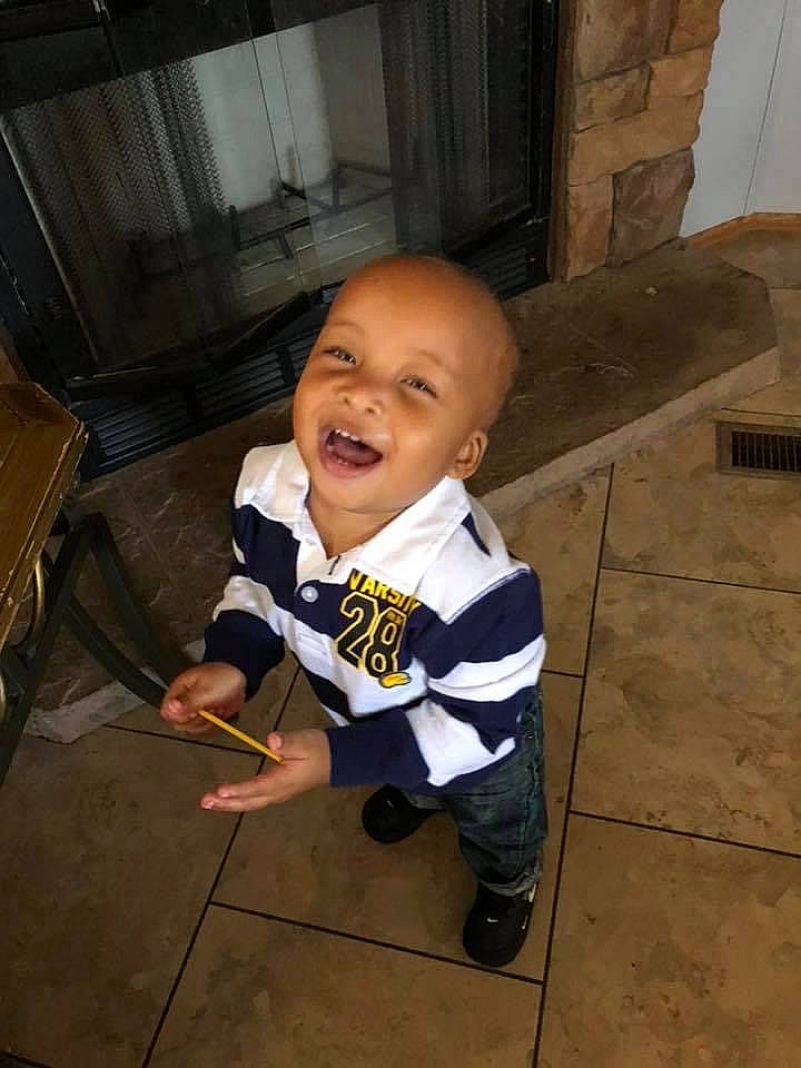 Zayden is registered to the contest to win money with this photo: baby, baby_toddler_clothing, child, floor, flooring, formal_wear, fun, happy, hardwood, person, sitting, sleeve, smile, suit, t_shirt, toddler, wood