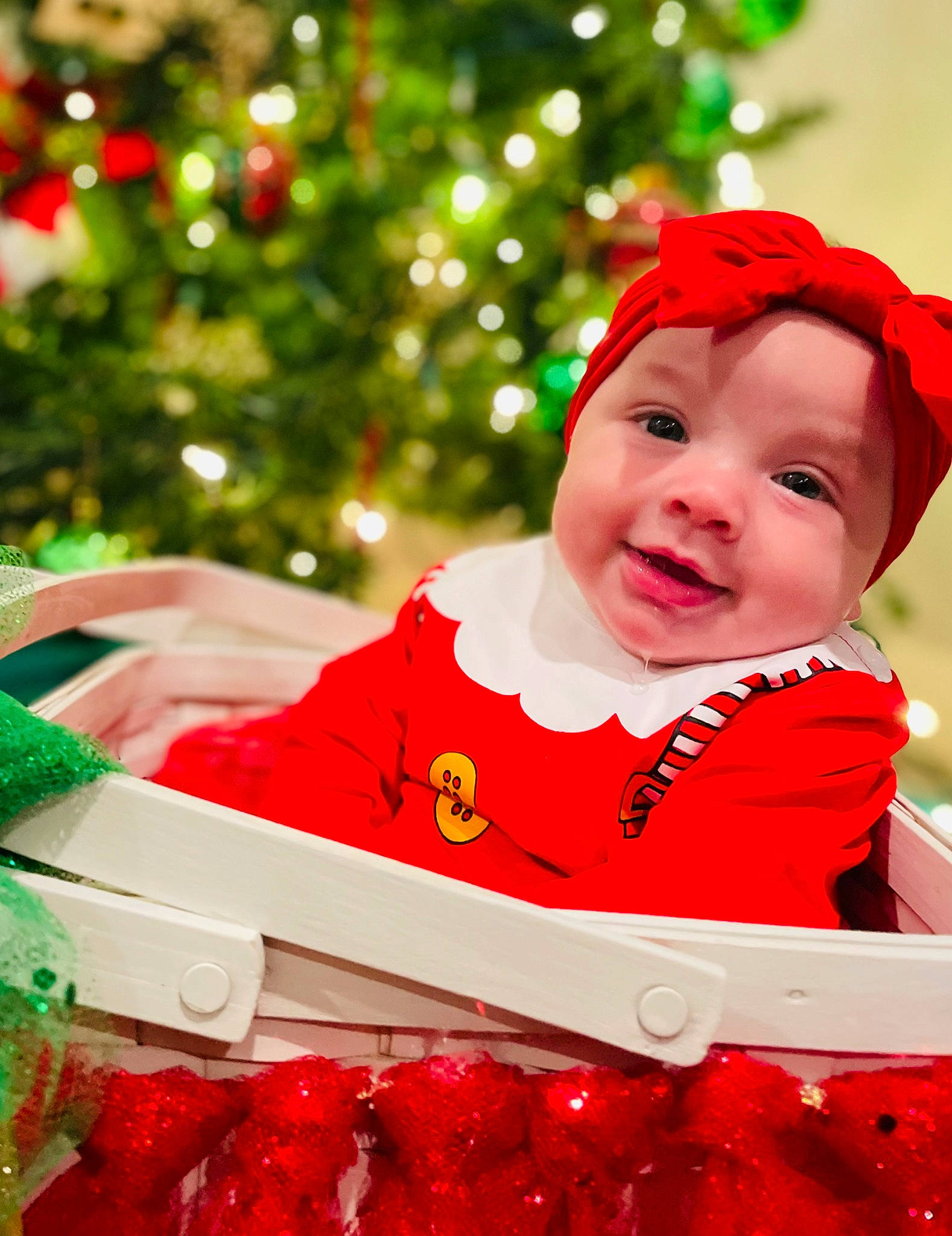 Justyce is registered to the contest to win money with this photo: baby, baby_toddler_clothing, carmine, christmas, christmas_decoration, christmas_eve, christmas_ornament, christmas_tree, event, green, happy, head, headwear, holiday, natural_foods, person, red, sleeve, smile, strawberry
