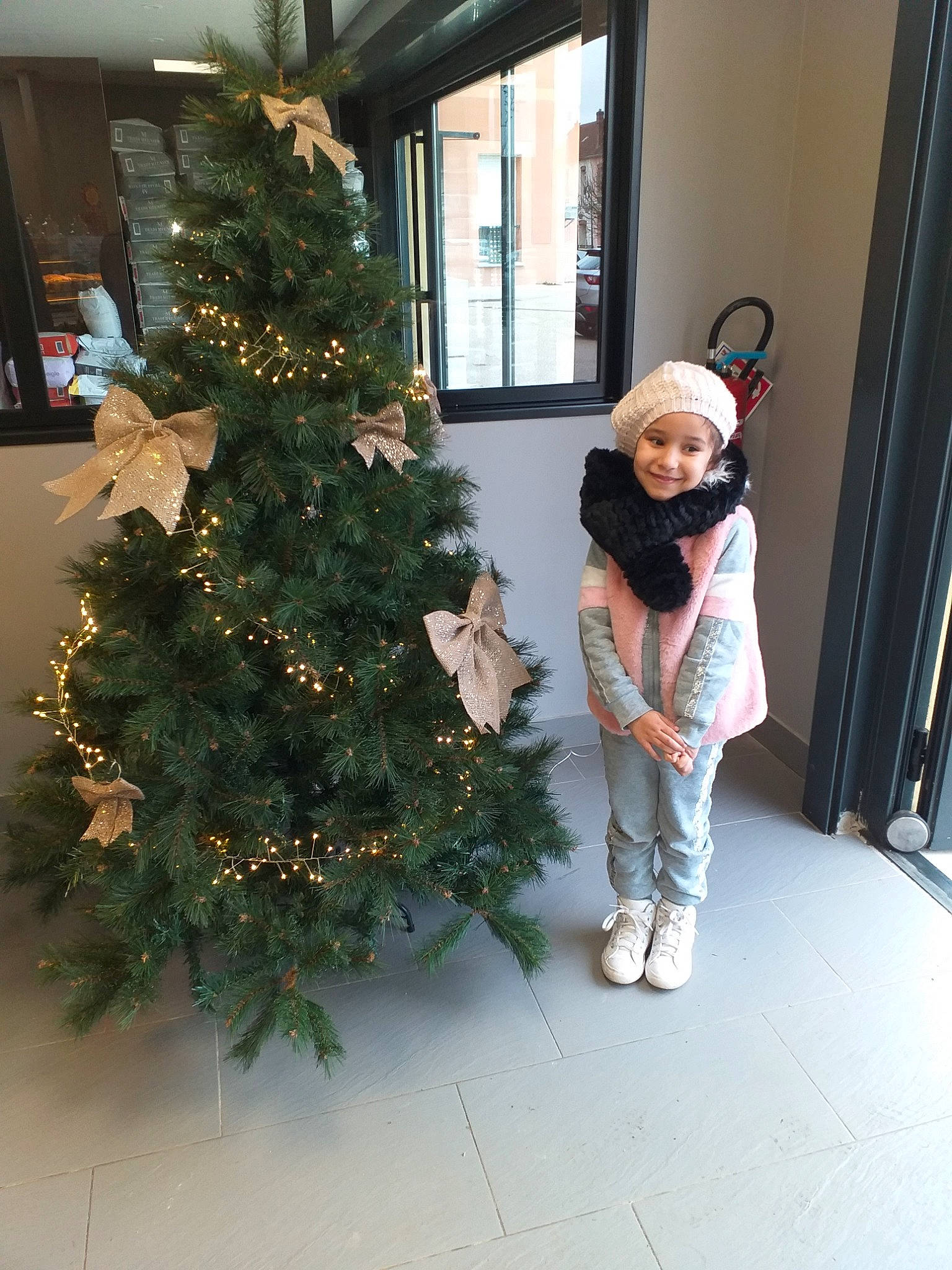 Chama a rejoint le concours — aidez-le/la à gagner de superbes lots ! christmas, christmas_decoration, christmas_eve, christmas_ornament, christmas_tree, colorado_spruce, event, fir, headwear, holiday, home, interior_design, joy, leg, outerwear, person, pine_family, plant, room, standing