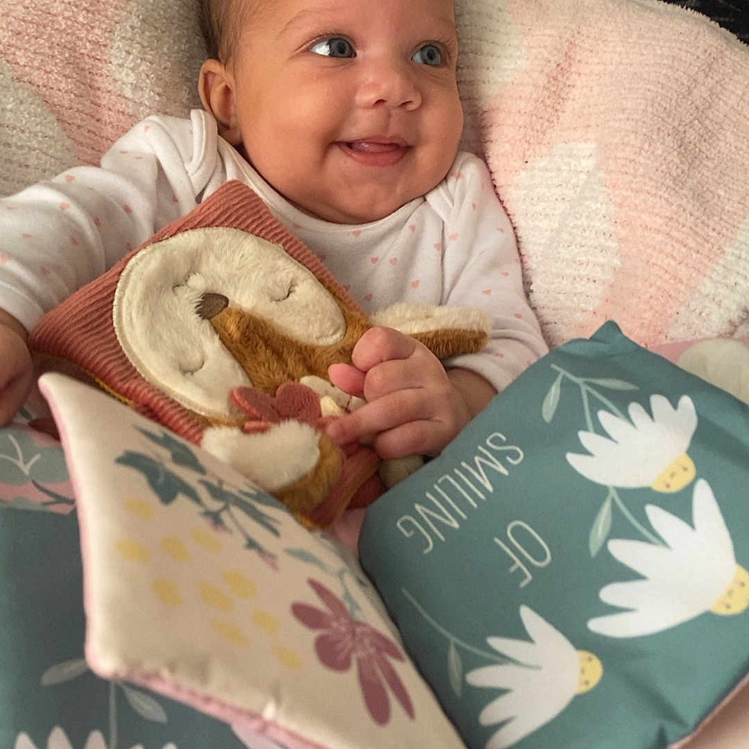 Sekaiyah joined the competition — help win amazing prizes! baby, blanket, blue, child, clothing, cozy, cute, fabric_book, flower_pattern, hands, happy, indoors, infant, person, pink, playtime, plush_toy, portrait, smiling, soft_toys