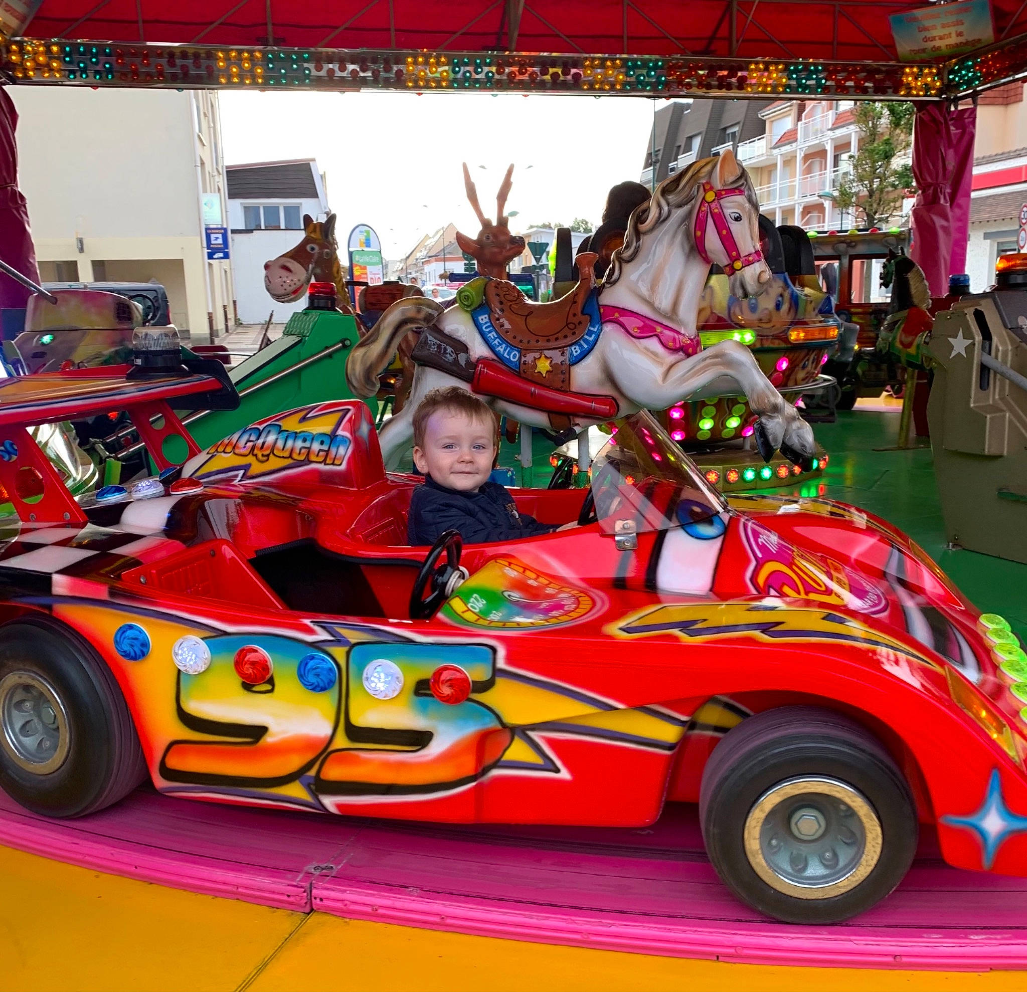 Louis participe au concours pour gagner de l'argent avec cette photo : amusement_ride, auto_part, automotive_design, automotive_exterior, automotive_tire, automotive_wheel_system, bumper, car, entertainment, event, fun, hood, joy, leisure, motor_vehicle, person, recreation, riding_toy, smile, tire