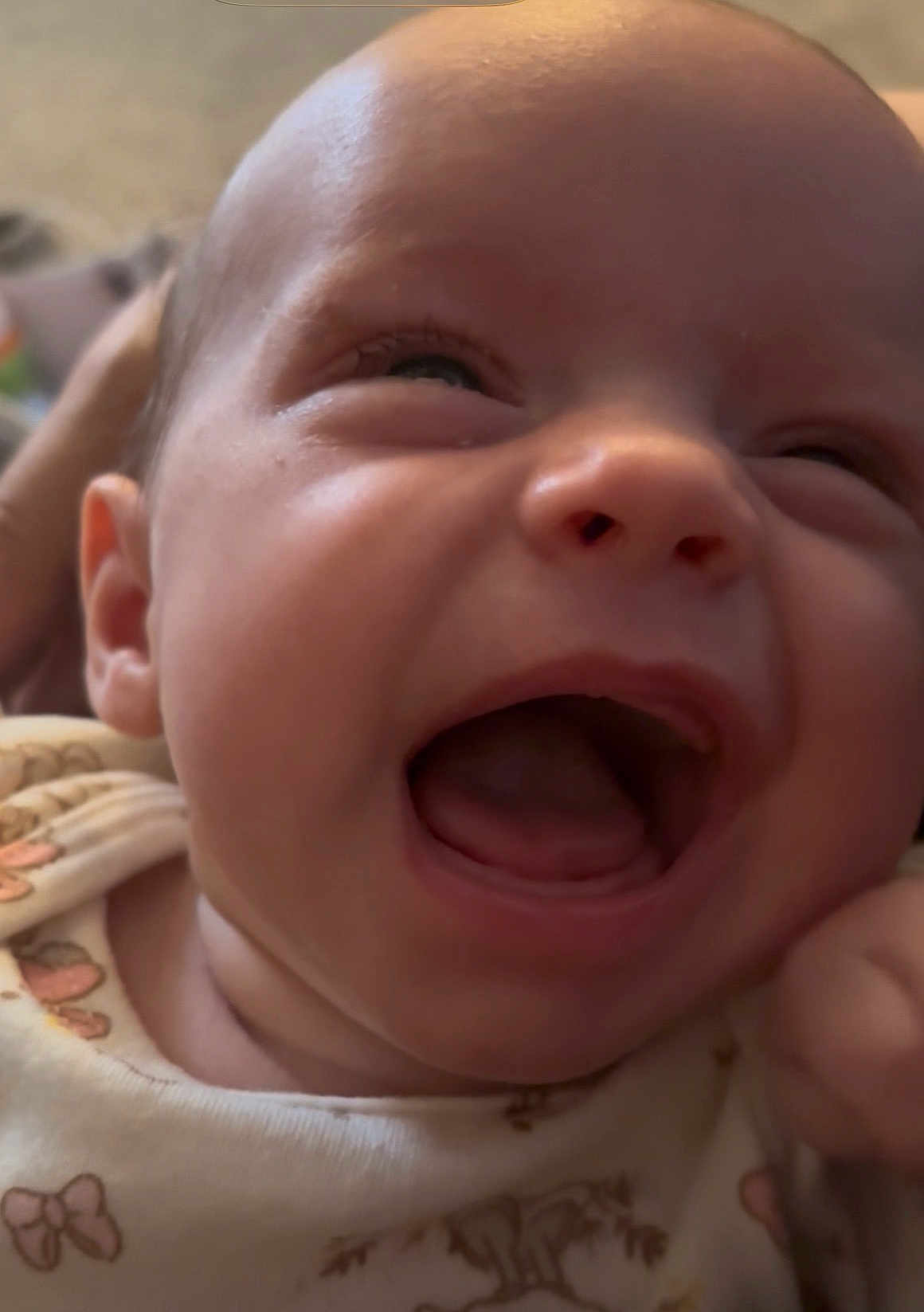 Charlotte is registered to the contest to win money with this photo: baby, close_up, smile, laughing, infant, face, child, cute, joyful, expression, mouth_open, eyes_squinting, clothing, pattern, soft_light, skin, portrait, indoors, happy, young