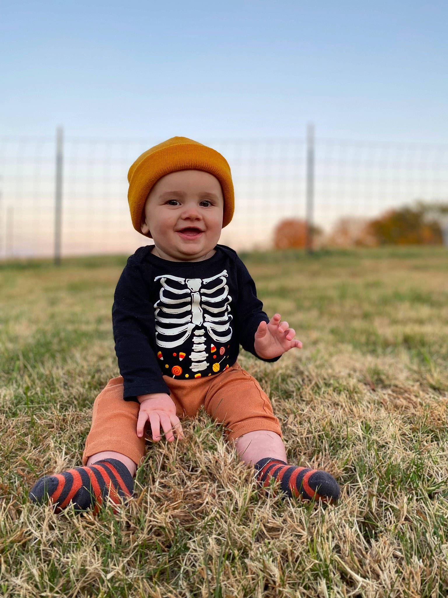 Ozzy joined the competition — help win amazing prizes! baby_toddler_clothing, ball, cap, child, eye, flash_photography, grass, grassland, happy, hat, headwear, joy, landscape, people, people_in_nature, person, plant, prairie, shoe, sitting