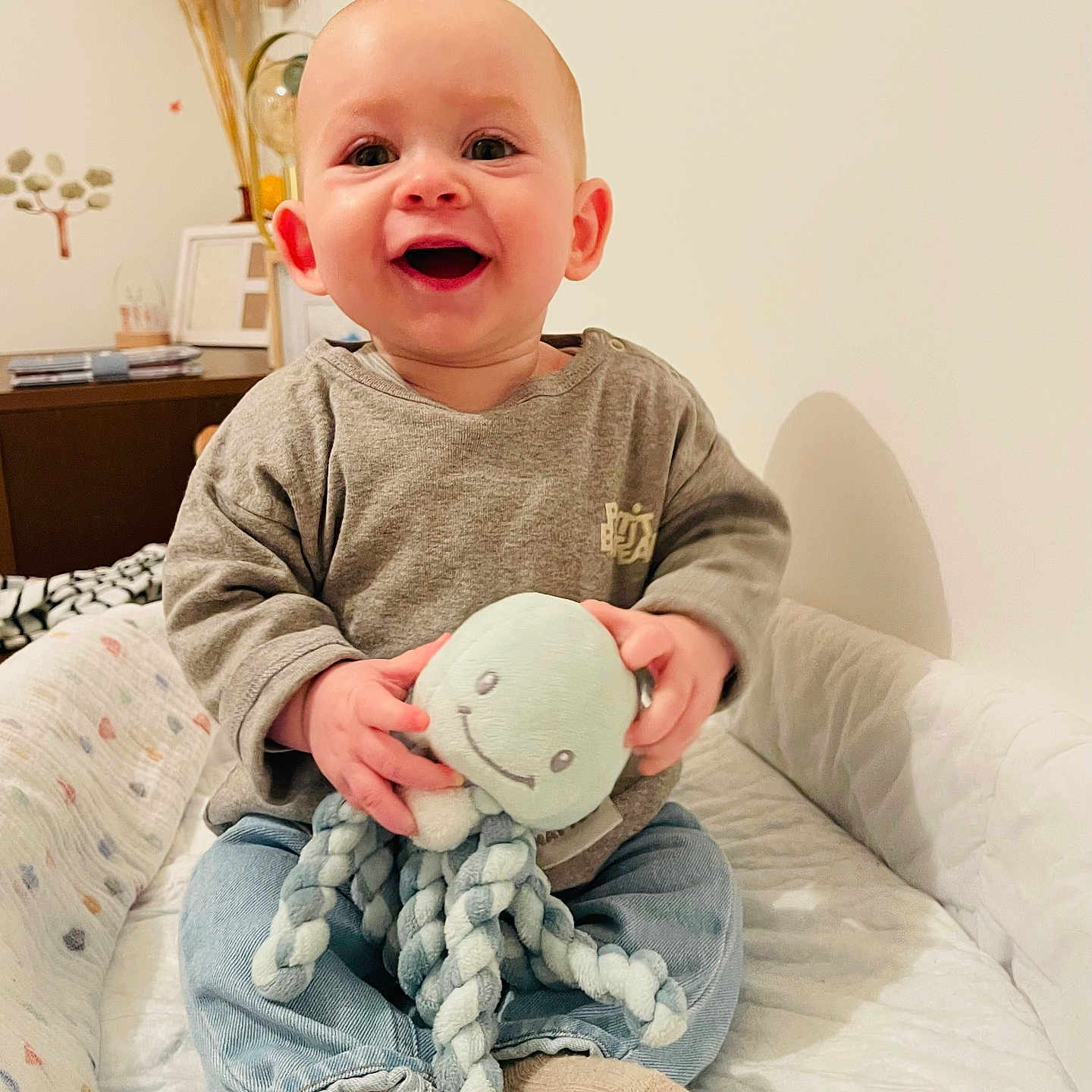 Lohann participe au concours pour gagner de l'argent avec cette photo : baby, babylaughing, bed, bedroom, clothing, face, furniture, happy, head, hosiery, indoors, jeans, pants, person, photography, portrait, sitting, sock, teddybear, toy