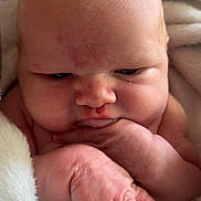 Rowan joined the competition — help win amazing prizes! baby, infant, close_up, face, hand, blanket, skin, newborn, cute, wrinkled_skin, expression, indoors, soft_texture, wrapped, portrait, chubby_cheeks, small_fingers, head, resting, peaceful