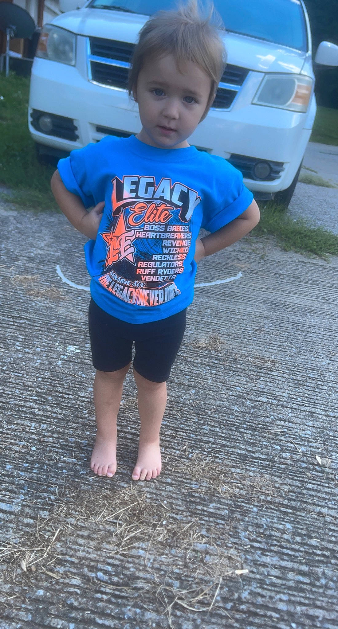 Ashtyn is registered to the contest to win money with this photo: asphalt, auto_part, automotive_design, automotive_exterior, automotive_lighting, automotive_tire, automotive_wheel_system, bumper, car, electric_blue, hood, motor_vehicle, parking, person, road_surface, sidewalk, t_shirt, toddler, vehicle, vehicle_door