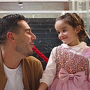 Eileen participe au concours pour gagner de l'argent avec cette photo : man, child, girl, smile, dress, pink, bow, rope, interaction, stairs, marble, indoor, happy, family, people, casual_clothing, glass, railing, portrait, playful