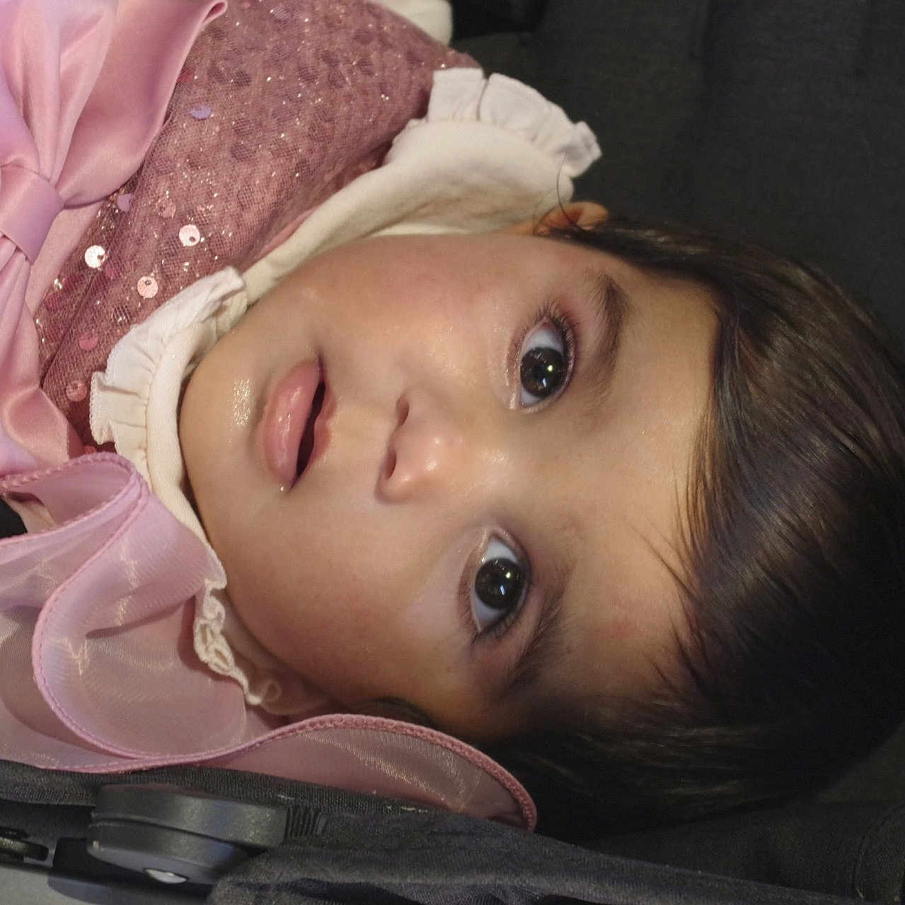 Nadeen a rejoint le concours — aidez-le/la à gagner de superbes lots ! baby, child, closeup, comfort, cute, expression, eyes, fabric, face, hair, infant, person, pink_clothing, portrait, resting, ruffles, sequins, soft_skin, stroller, young